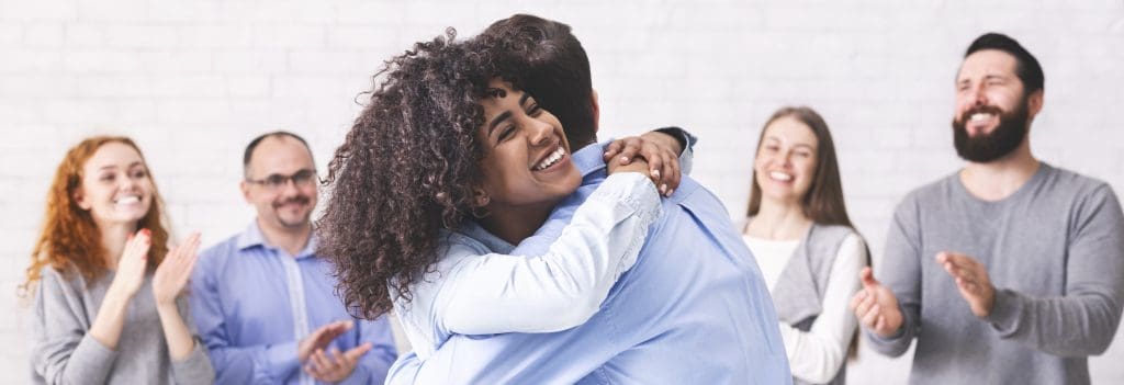Woman hugging a man in a support group