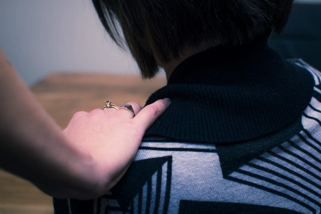 Hand on the shoulder helping someone through alcoholism