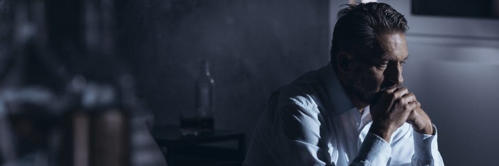 man suffering with depression after cocaine. Looking out the window.