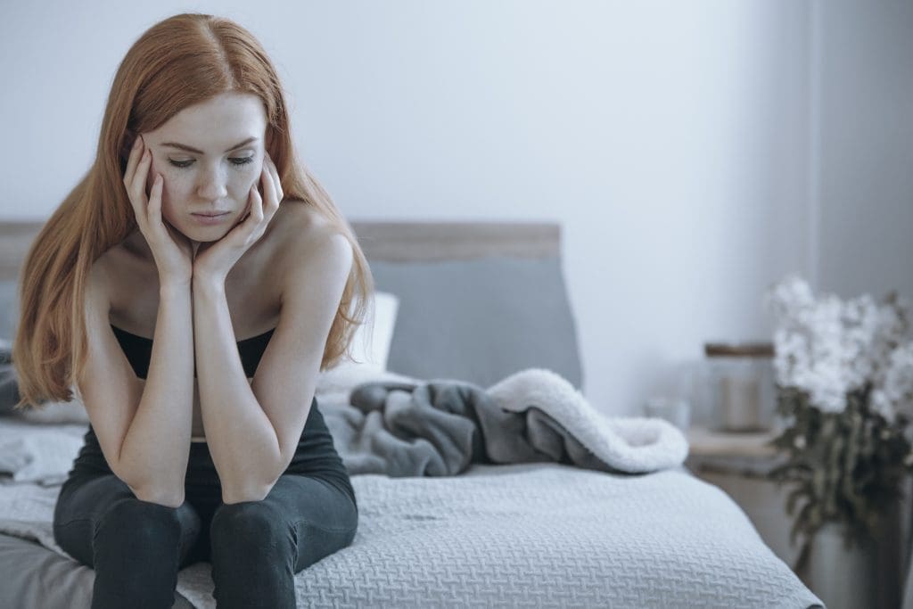 girl sitting on the bed suffering with bulimia