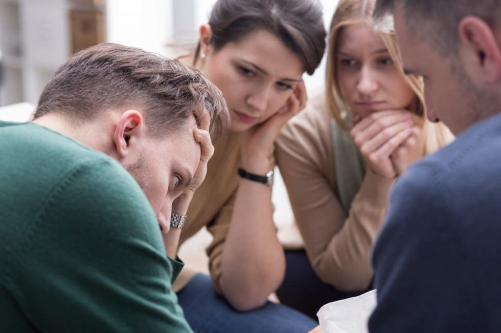 Group consoling a distressed man