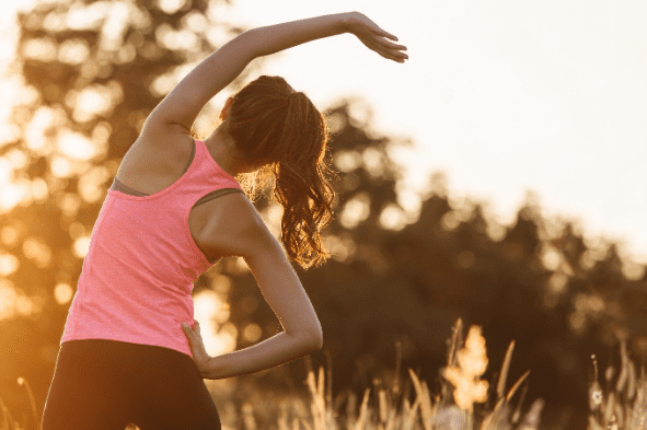 Woman doing yoga in sunrise rural setting