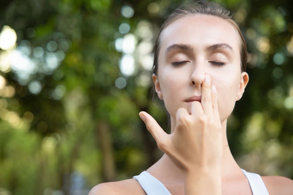 Woman practising Yoga breathing techniques as part of breathwork therapy