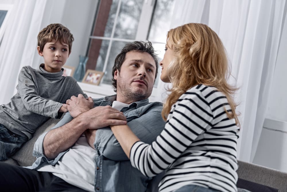 son and mother helping a father with his addiction problem